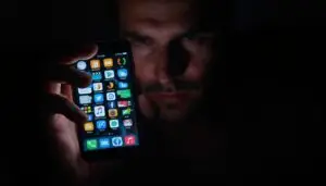 A Persons Hand Holding A Smartphone The Screen Reflecting A Jumble Of App Icons Chat